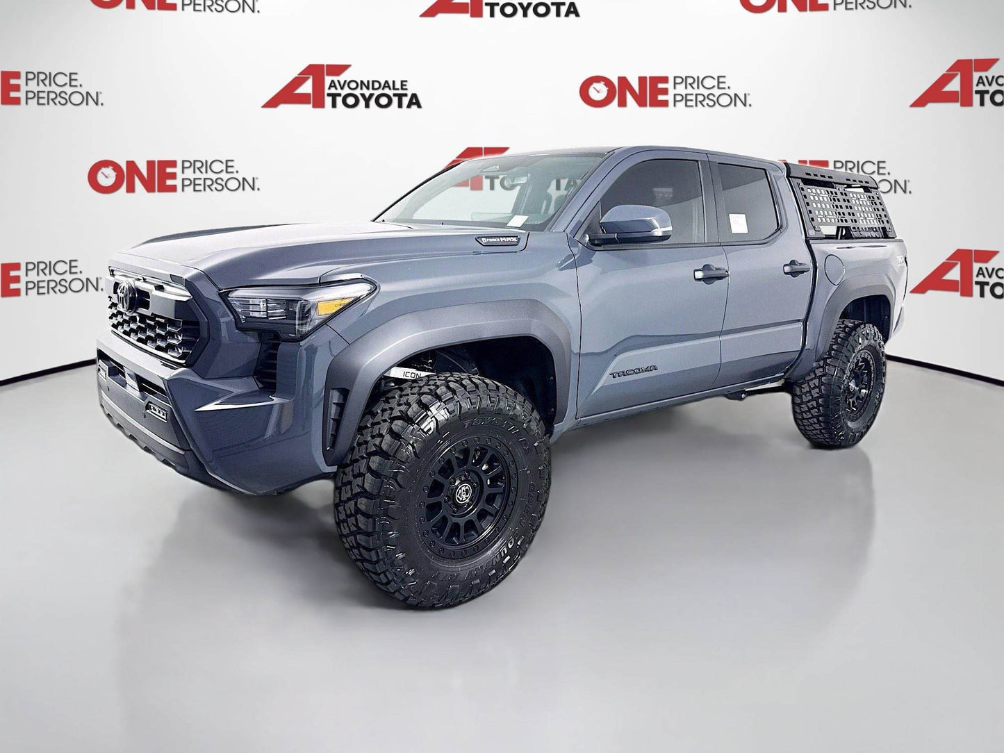 2025 Toyota Tacoma equipped with 2025 Tacoma Fox 2.5 Suspension System Package and off-road tires in showroom setting