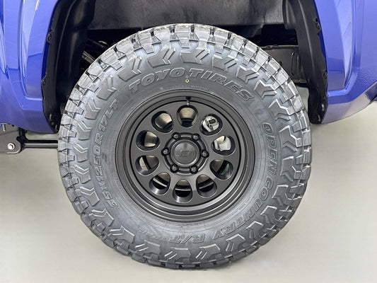 Blue 2025 Toyota Tacoma with 2025 Tacoma with off-road tires installed by dealership