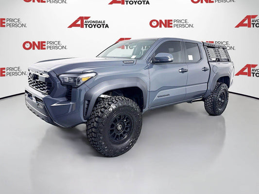 2025 Toyota Tacoma equipped with 2025 Tacoma Fox 2.5 Suspension System Package and off-road tires in showroom setting