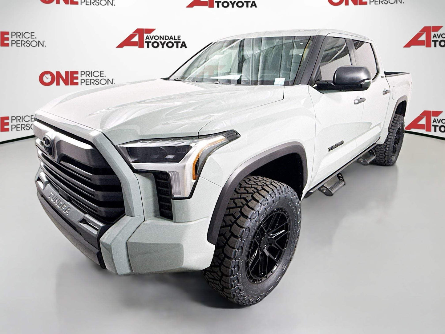 White 2025 Tundra with 3.5-inch lift, black off-road wheels, and rugged tires in showroom