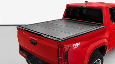 Tri-Fold Hard Tonneau Cover on red pickup truck bed with sleek design and self-latching system