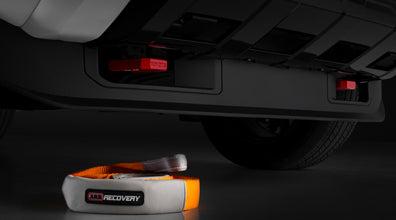 Front Tow Hooks in black heavy-duty metal mounted on vehicle frame with orange and gray recovery strap nearby