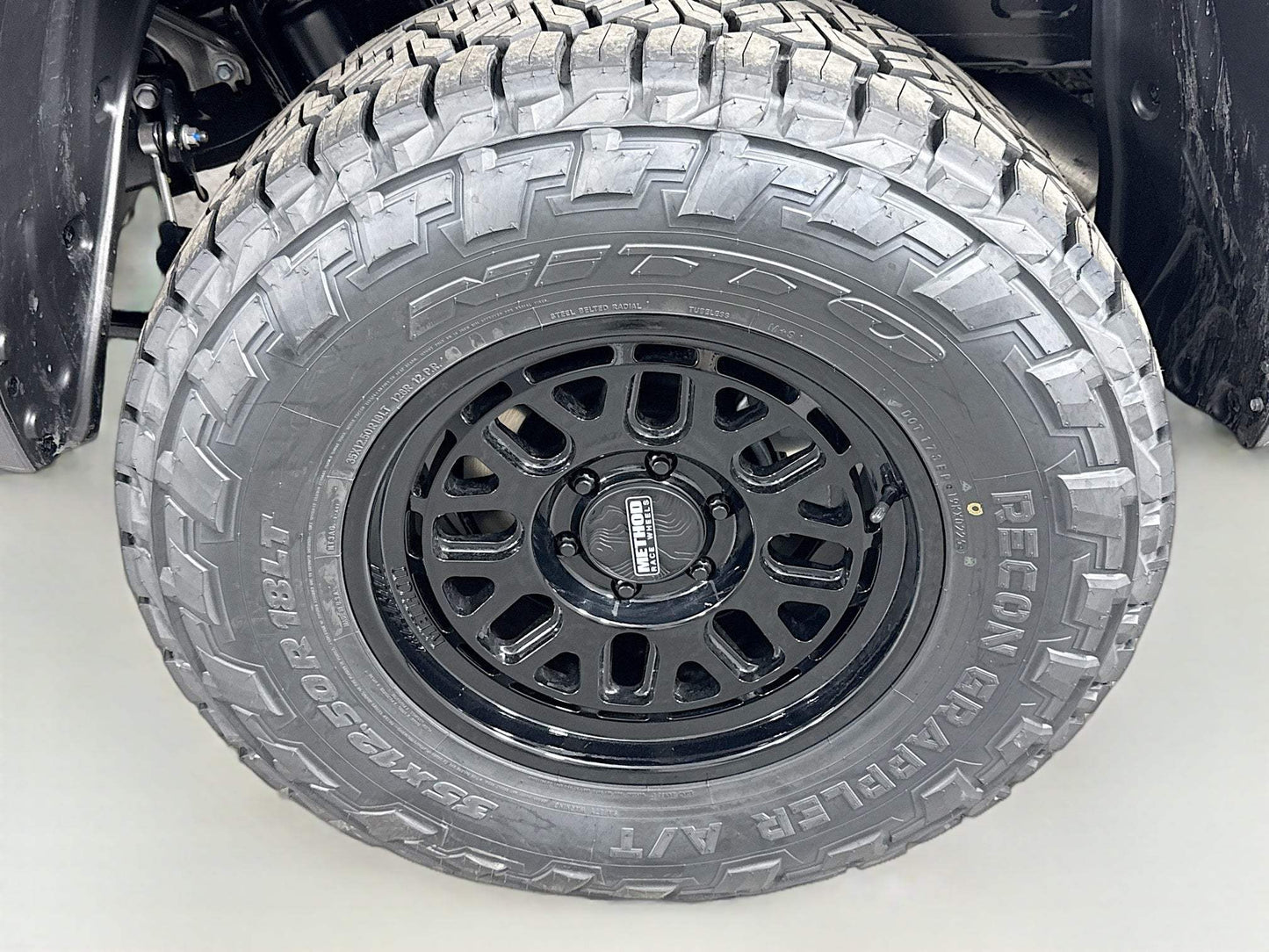 Close-up of black rugged alloy wheel and all-terrain tire on Toyota Tundra wheel and tire package