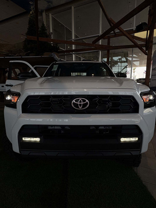 White Toyota truck in a showroom setting