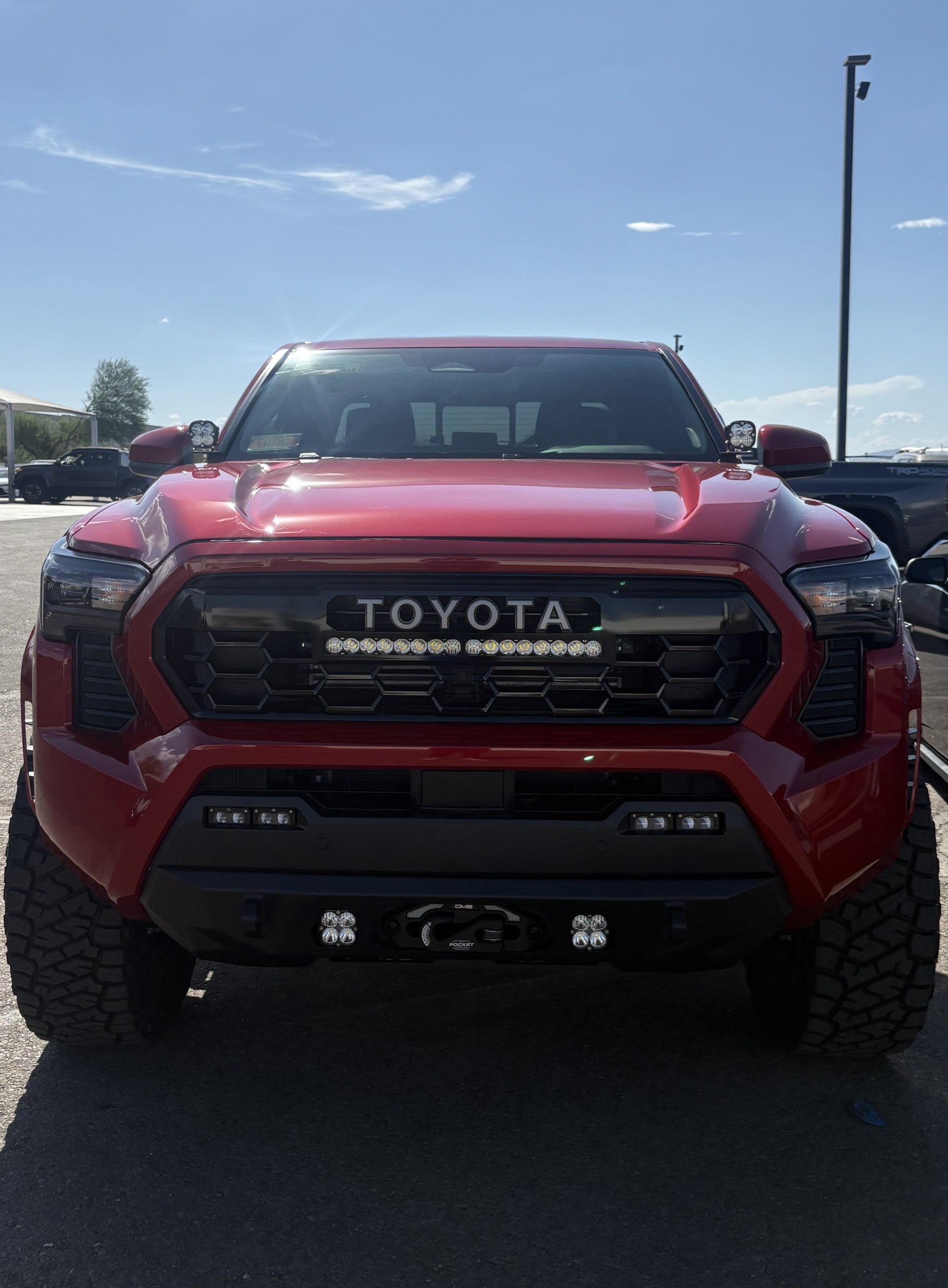 Front view of red Toyota truck with TRD Pro Grille Conversion Kit and integrated light bar installed